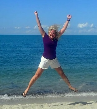 Jyll Hoyrup jumping for joy on the beach in Belize